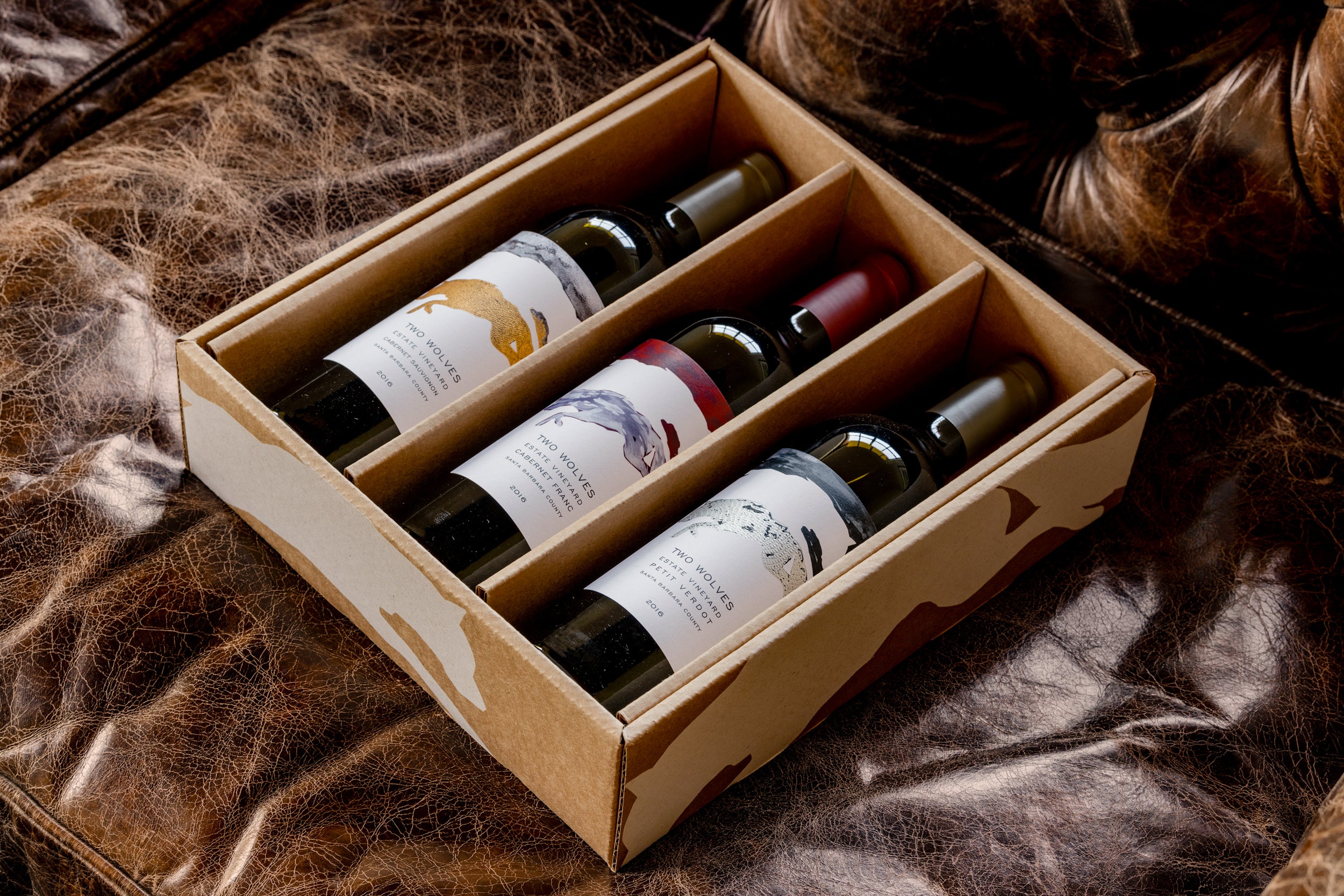 Box of wine bottles on a textured brown surface